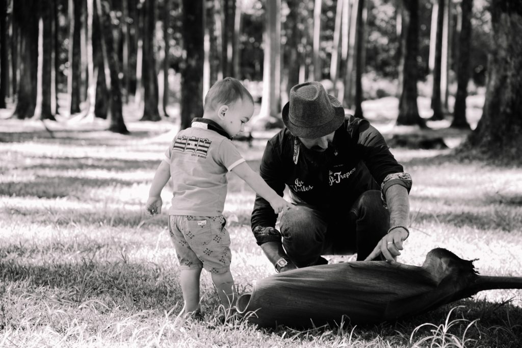 Un père et son enfant, en noir et blanc, dans la lumière